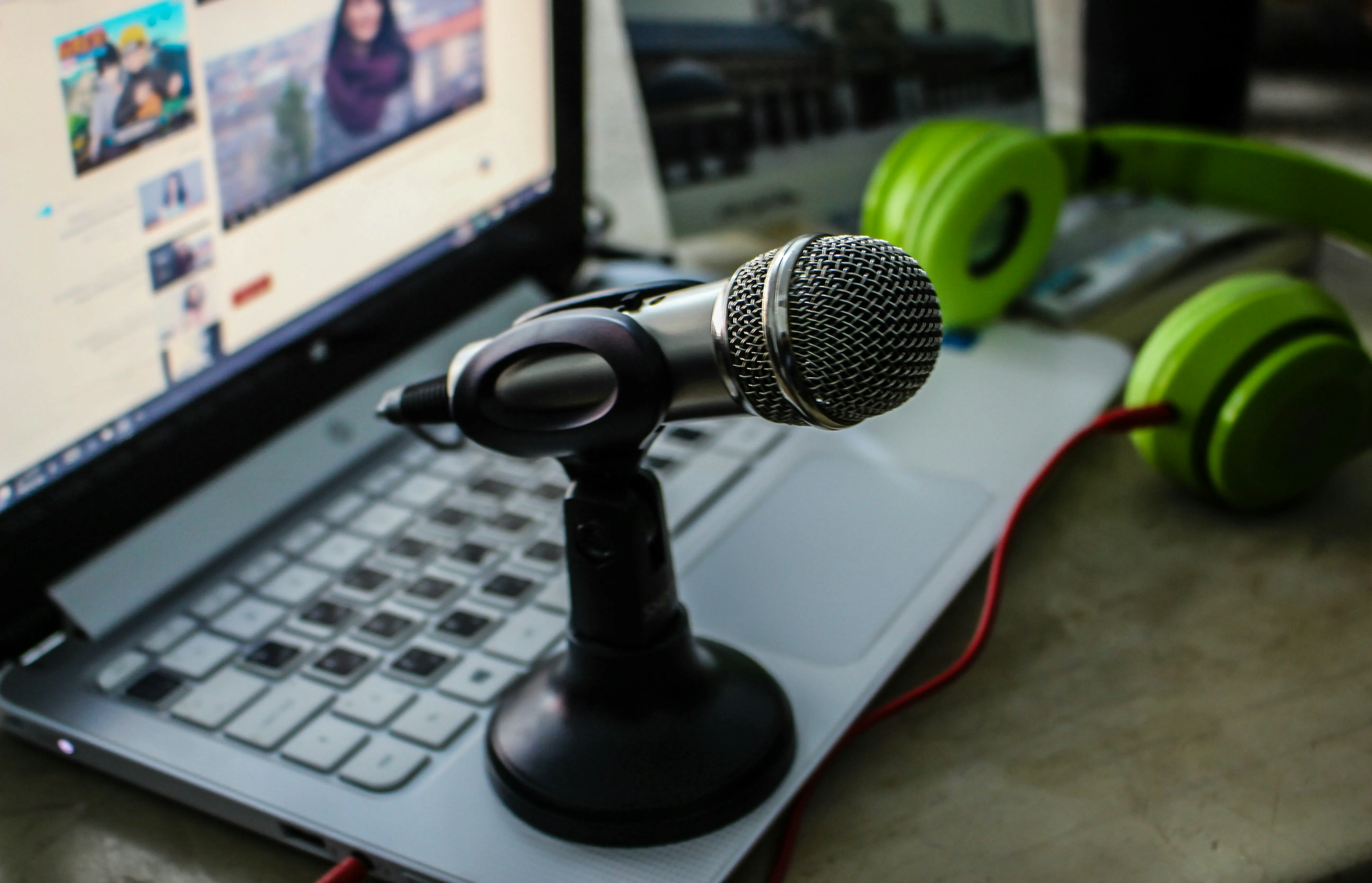 Desktop microphone in front of a laptop and headphones