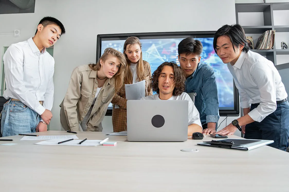 Remote team gathered around a laptop in an office