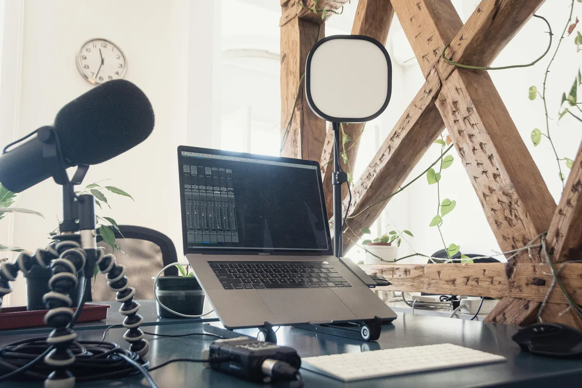 A microphone beside a laptop on a desk, suggesting voice typing on a desktop workspace