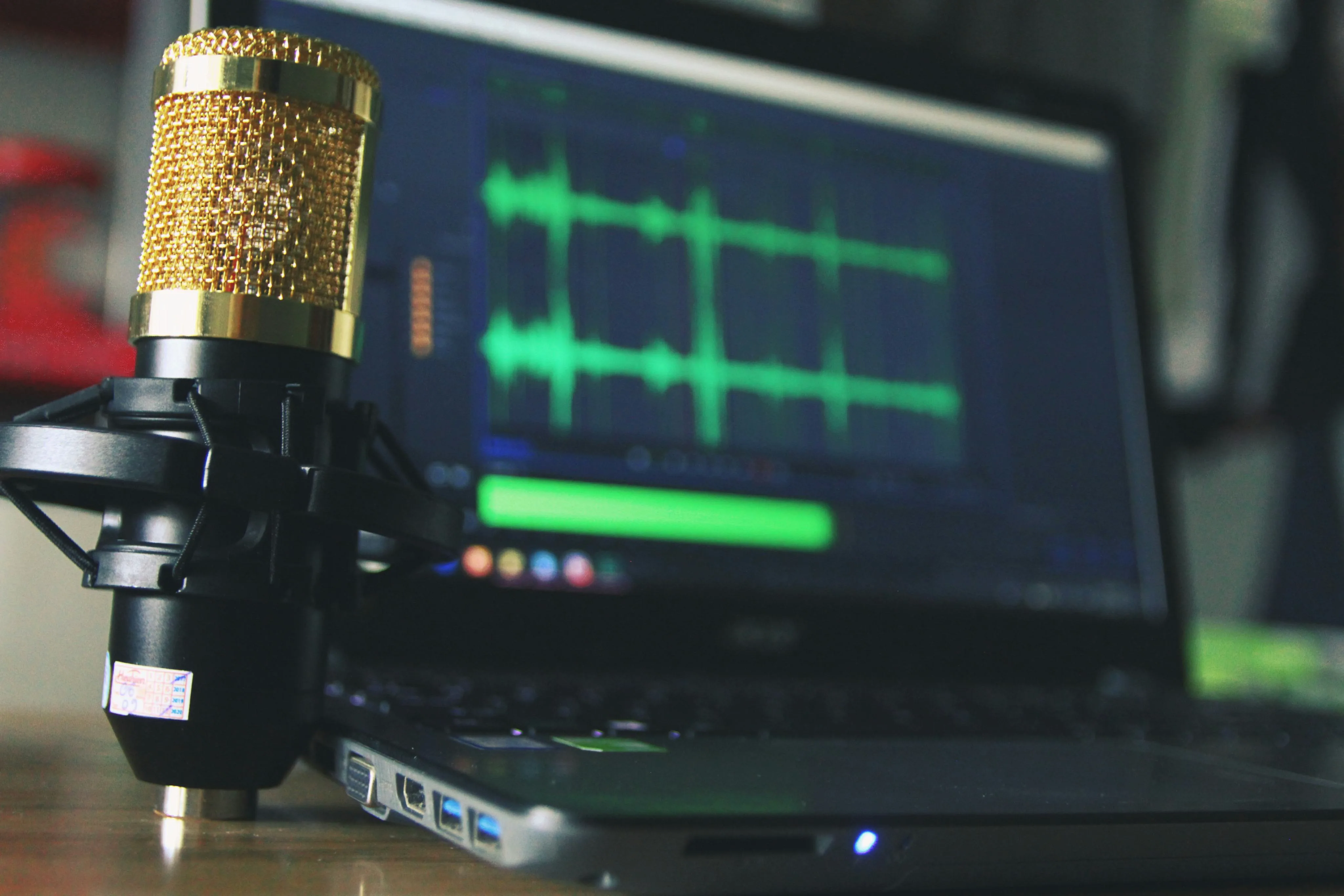 Microphone beside a laptop showing audio waveforms